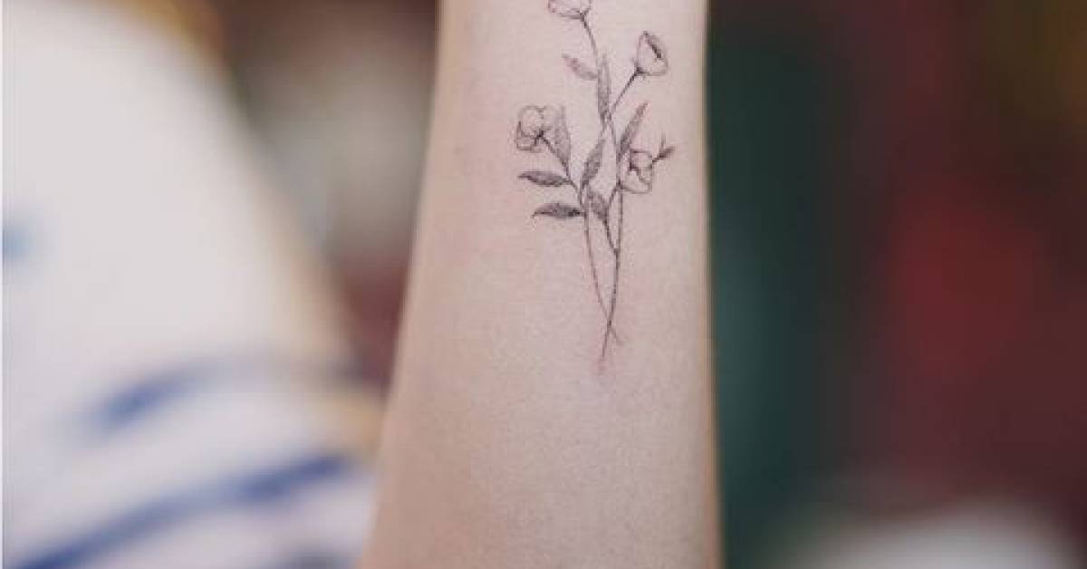 Fine line style flowers on the left forearm.
