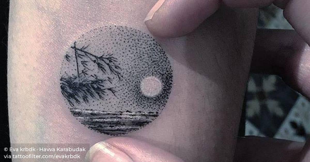 Landscape circle tattoo on the inner forearm.