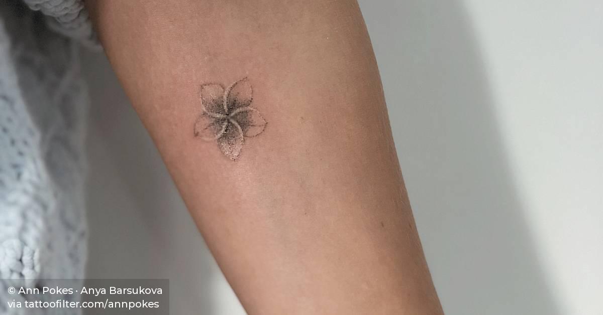 Frangipani tattoo on the inner forearm.