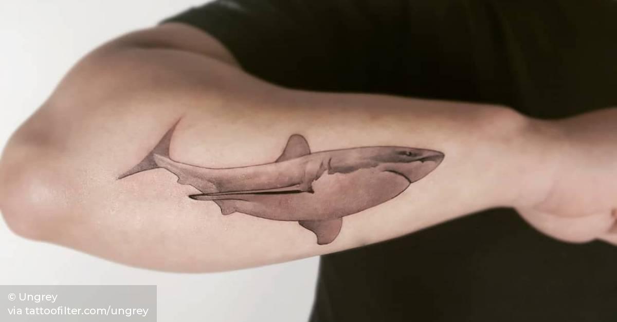 Single needle shark tattoo on the forearm.