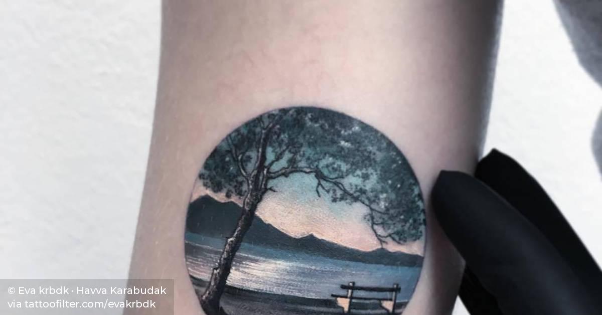 Landscape circle tattoo on the right bicep.