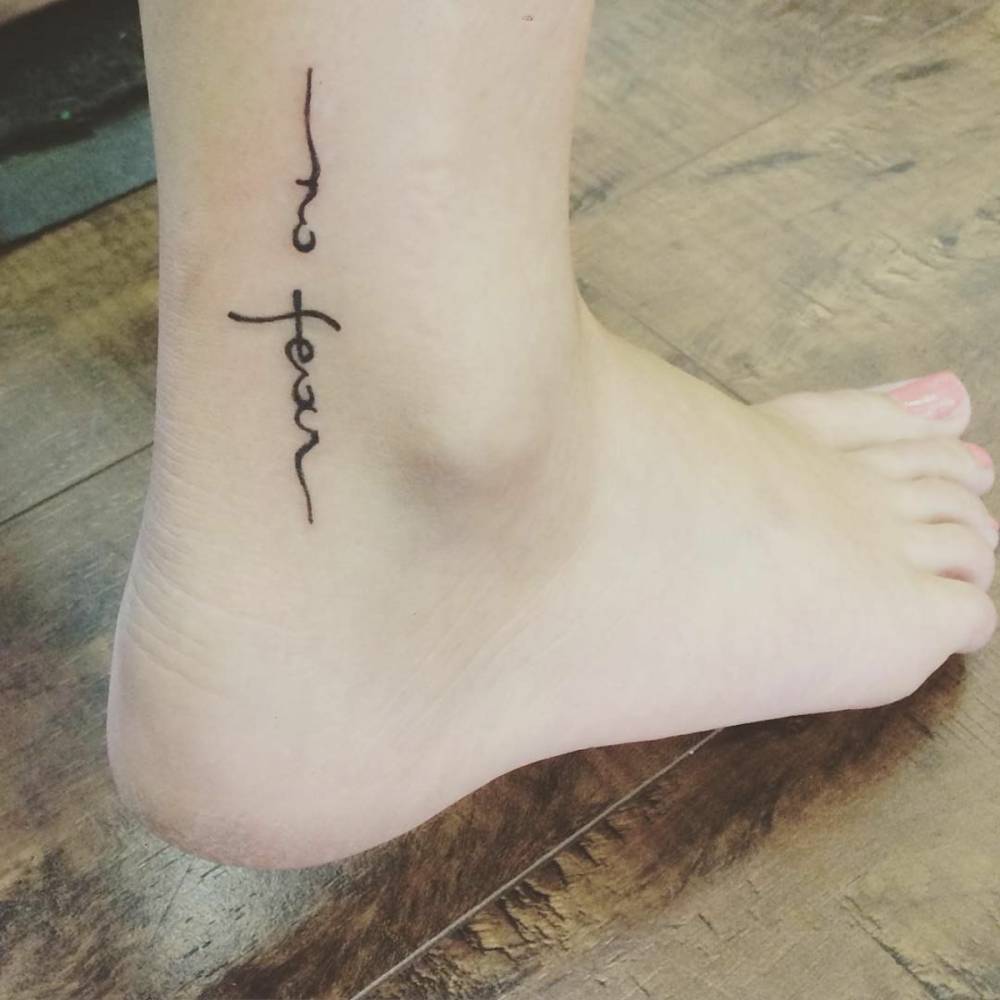 Ankle tattoo saying "No fear".