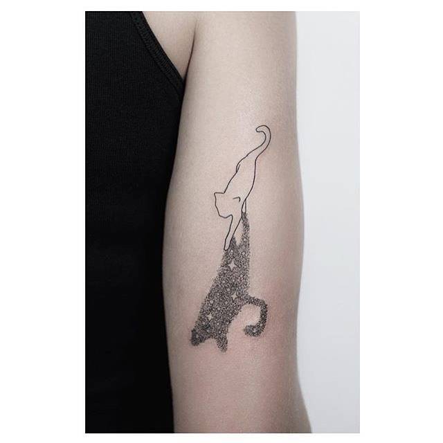 Cat and its shadow tattoo on the back of the right arm