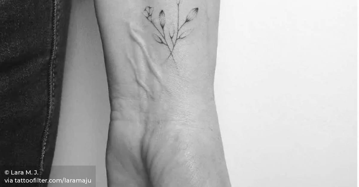 Hand poked flower tattoo on the left inner wrist.