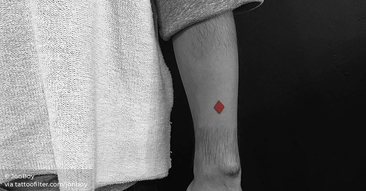 Red diamond tattoo on the left forearm.