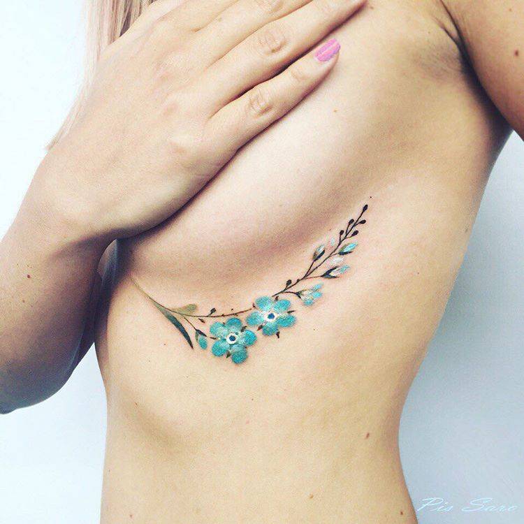 Underboob forget-me-not flower tattoo.