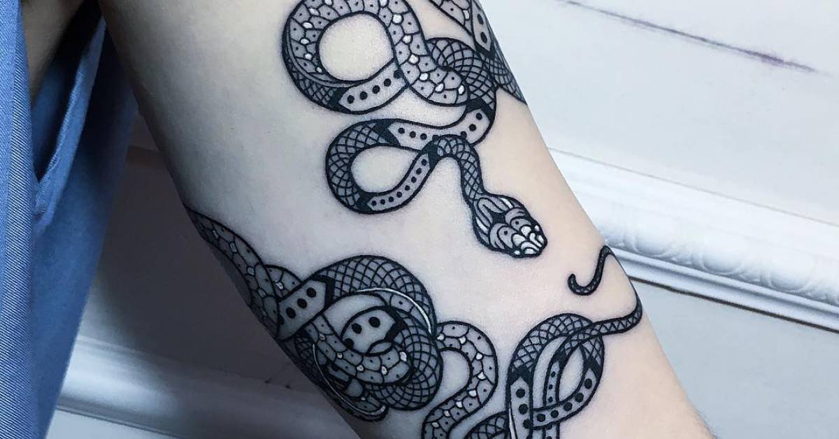 Snake bracelet tattoo on the left upper arm.