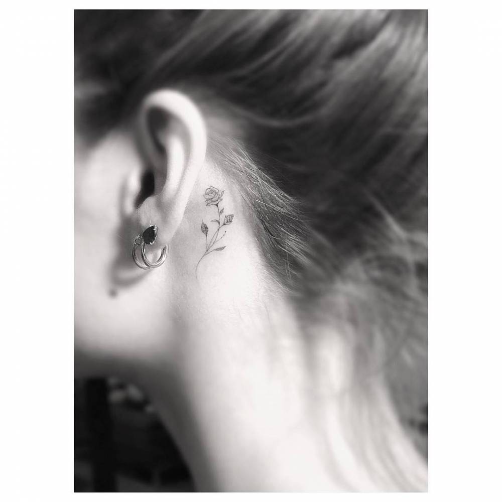 Small rose tattoo behind the left ear.