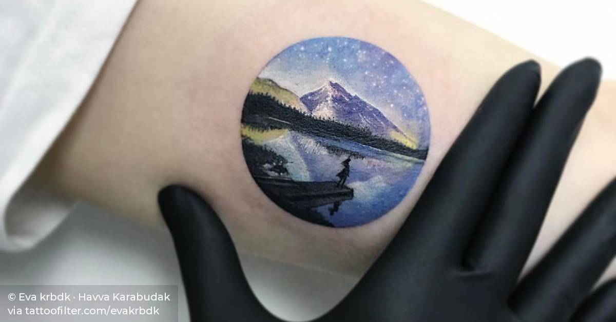 Circle landscape tattoo on the left inner arm.