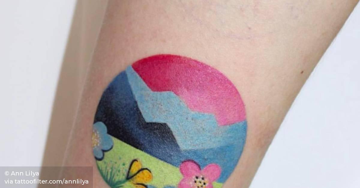 Landscape circle tattoo on the inner forearm.