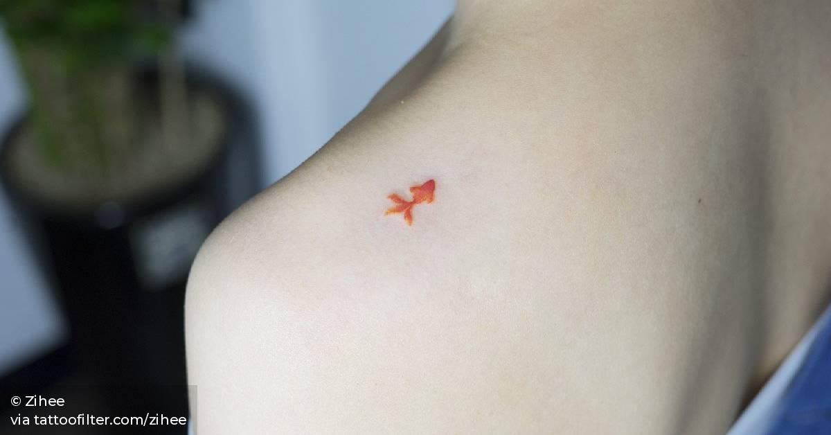 Tiny goldfish tattoo on the left shoulder.
