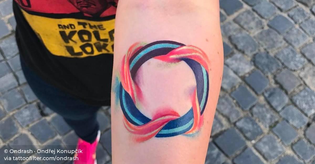Abstract circle tattoo on the left inner forearm.