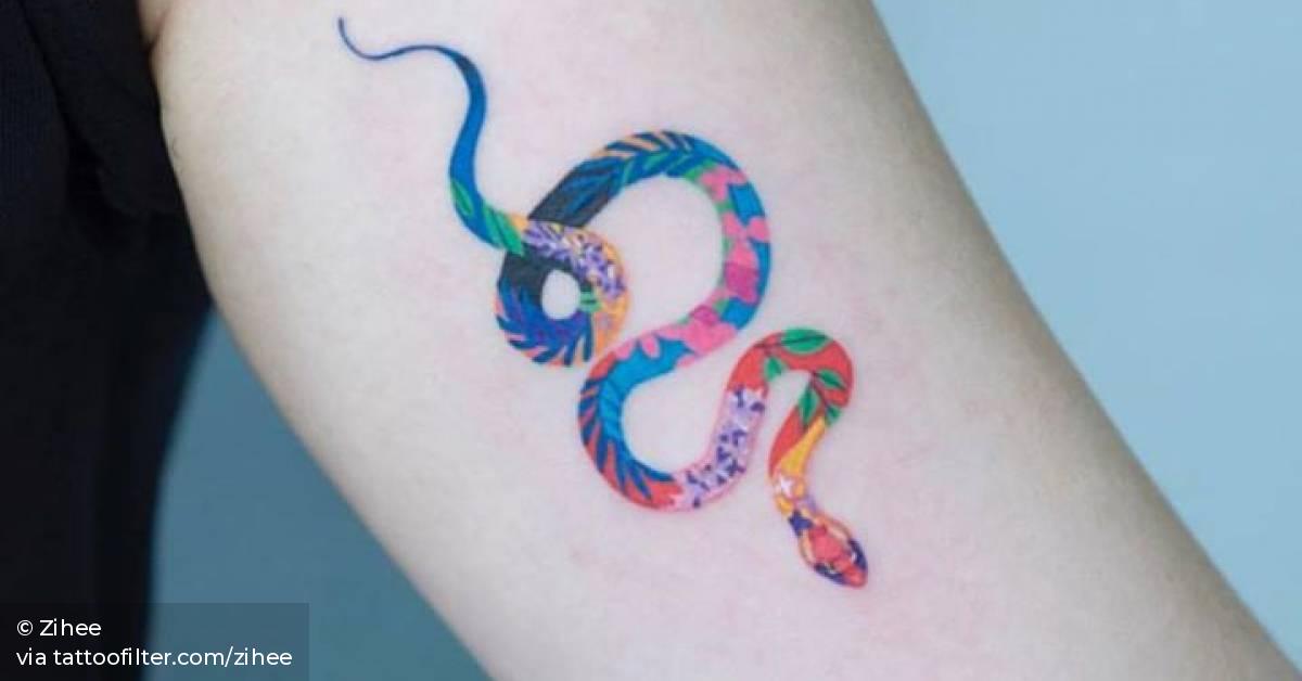 Floral snake tattoo on the left inner arm.