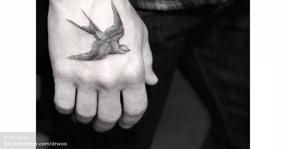 Classic fine line swallow tattoo on the right hand.