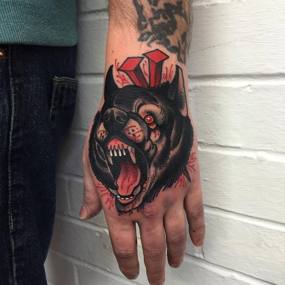 Neotraditional wolf head tattoo on the left hand.