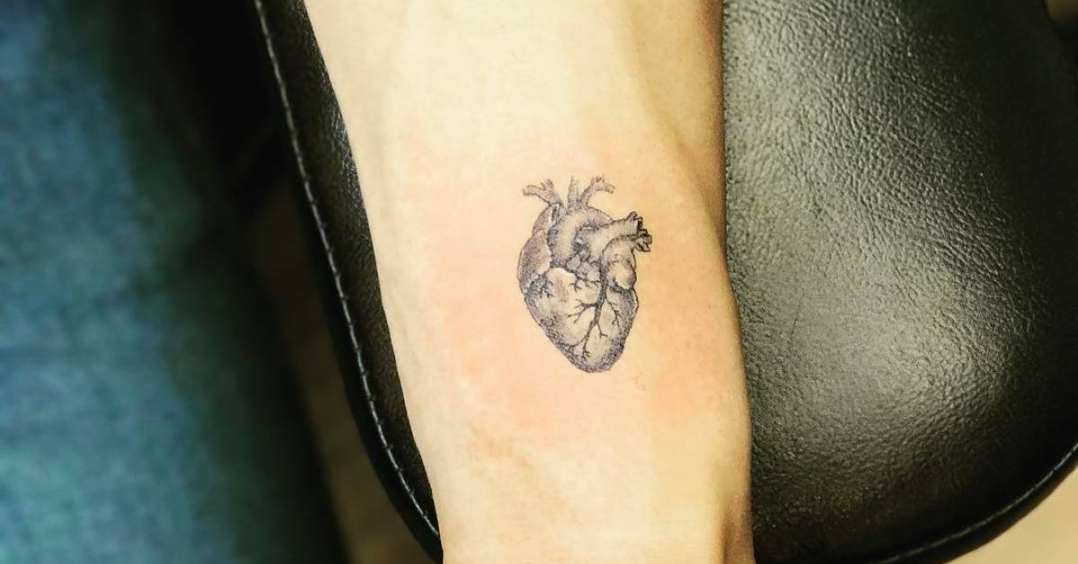Fine line anatomical heart tattoo on the left inner