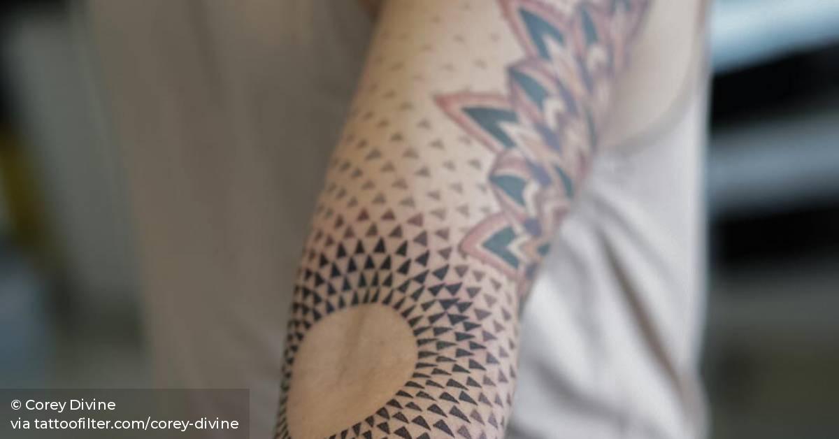 Op art circle tattoo on the left inner elbow.