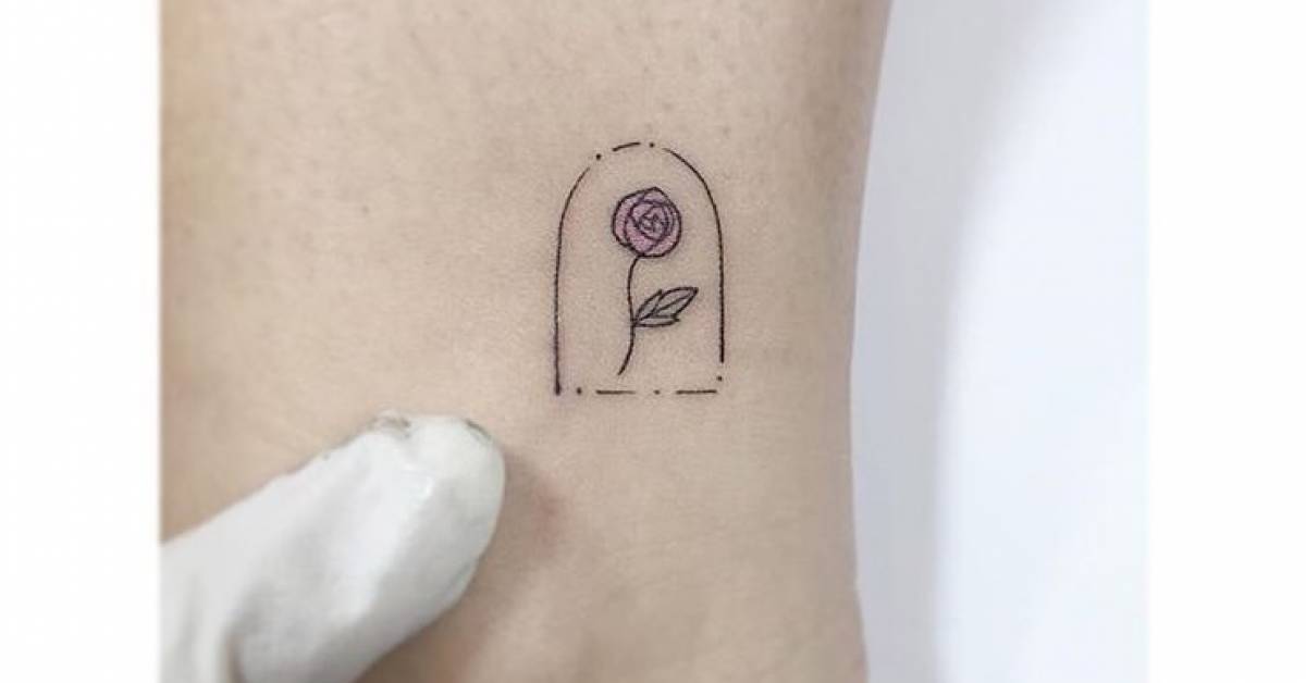 Minimalist pink rose in a glass dome tattoo on the