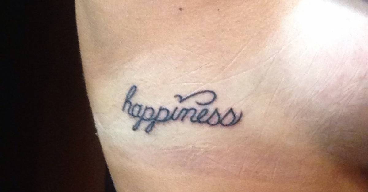 Side tattoo saying "Happiness" on Caitie.
