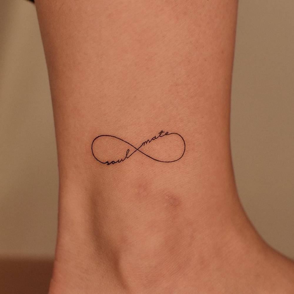 Fine line infinity symbol + "soul mate" tattoo