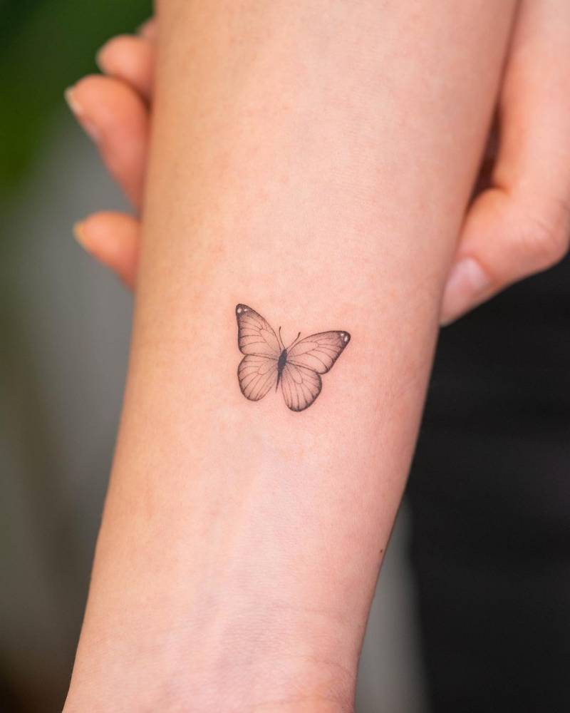 Single needle butterfly tattoo on the inner forearm