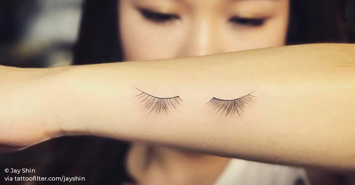Eyelash tattoo on the left forearm.