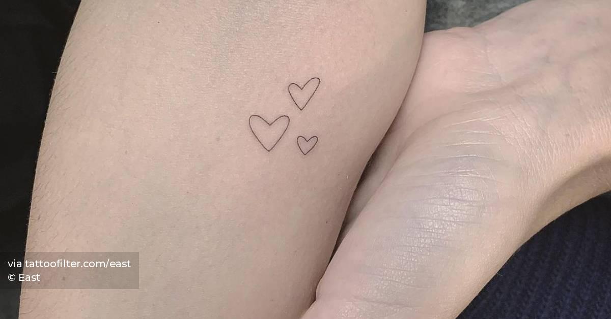Minimalist hearts tattoo on the inner forearm