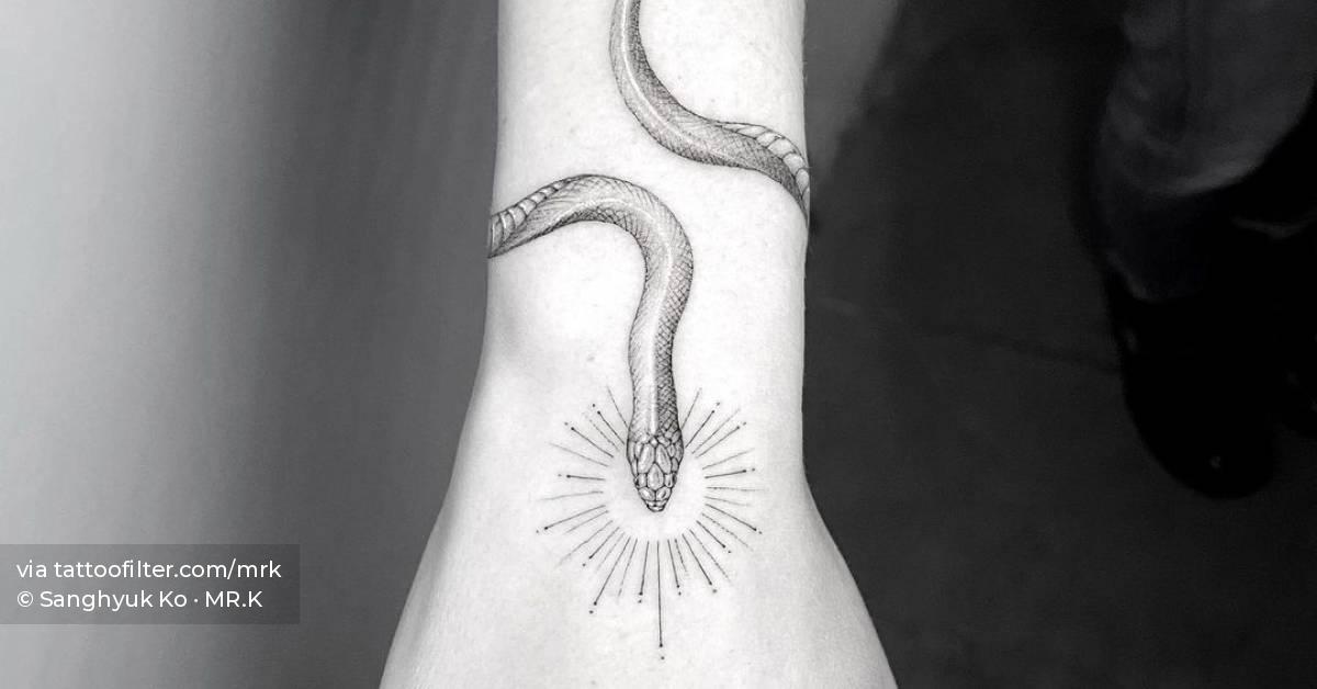 Single needle snake bracelet tattoo on the forearm.
