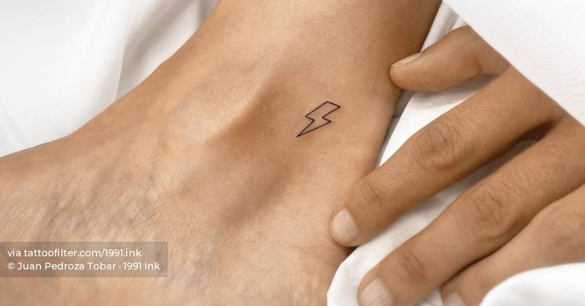 Minimalist lightning bolt tattoo on the ankle.