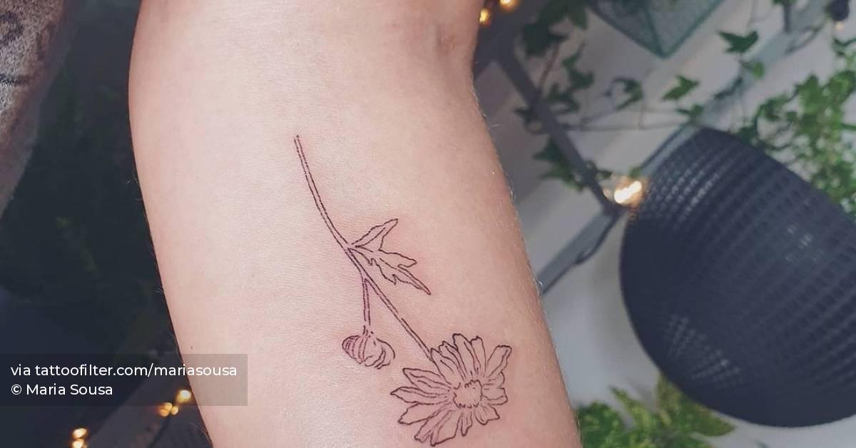 Fine line daisy flower tattoo on the inner forearm.