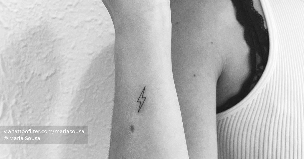 Minimalist lightning bolt tattoo on the wrist.