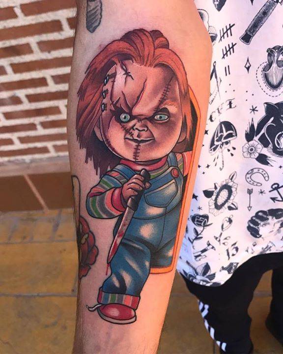 Tatuaje de Chucky de estilo neotradicional en el interior del antebrazo derecho.