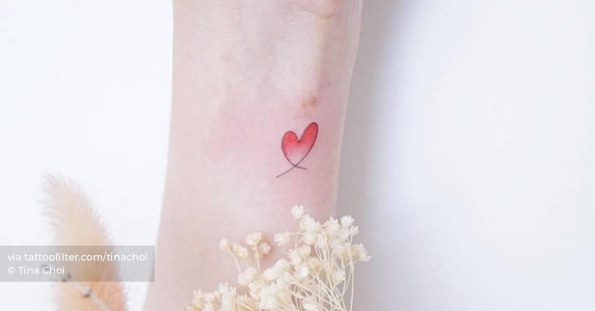 Minimalist heart tattoo on the wrist.