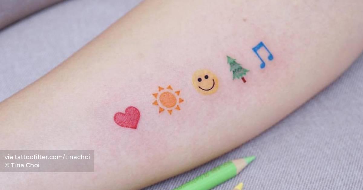 Watercolor emojis tattoo on the inner forearm.