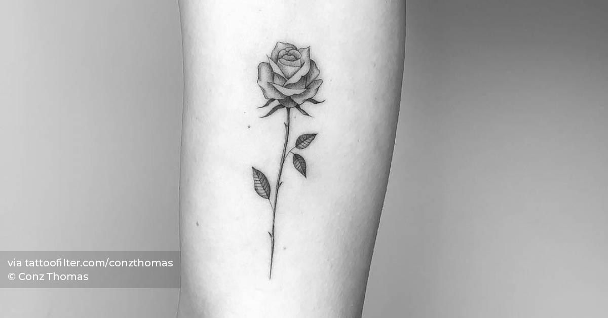 Single needle rose tattoo on the inner arm.