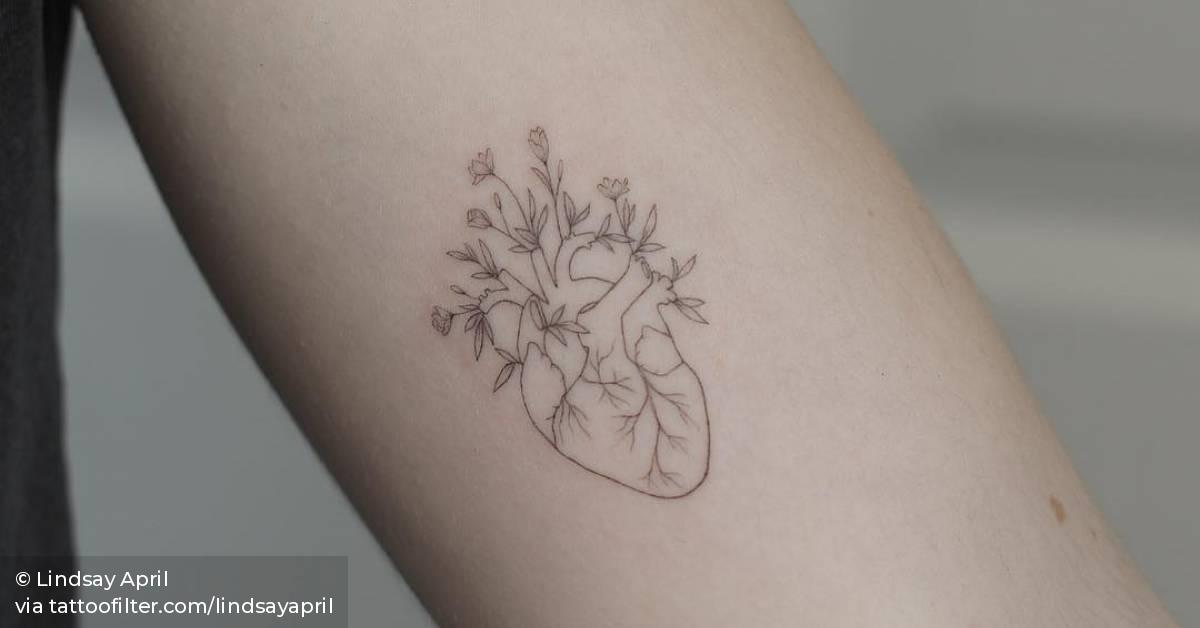 Single needle flower heart tattoo on the left inner