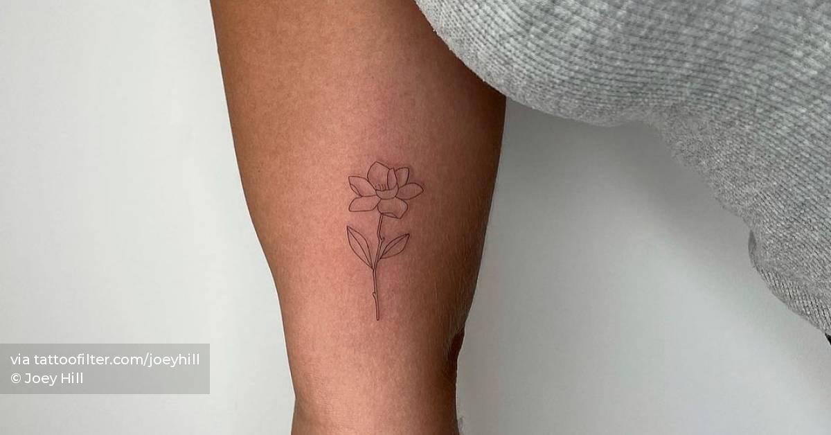 Fine line flower tattoo on the inner arm.