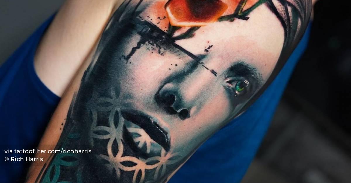 Graphic flower head woman tattoo on the upper arm.