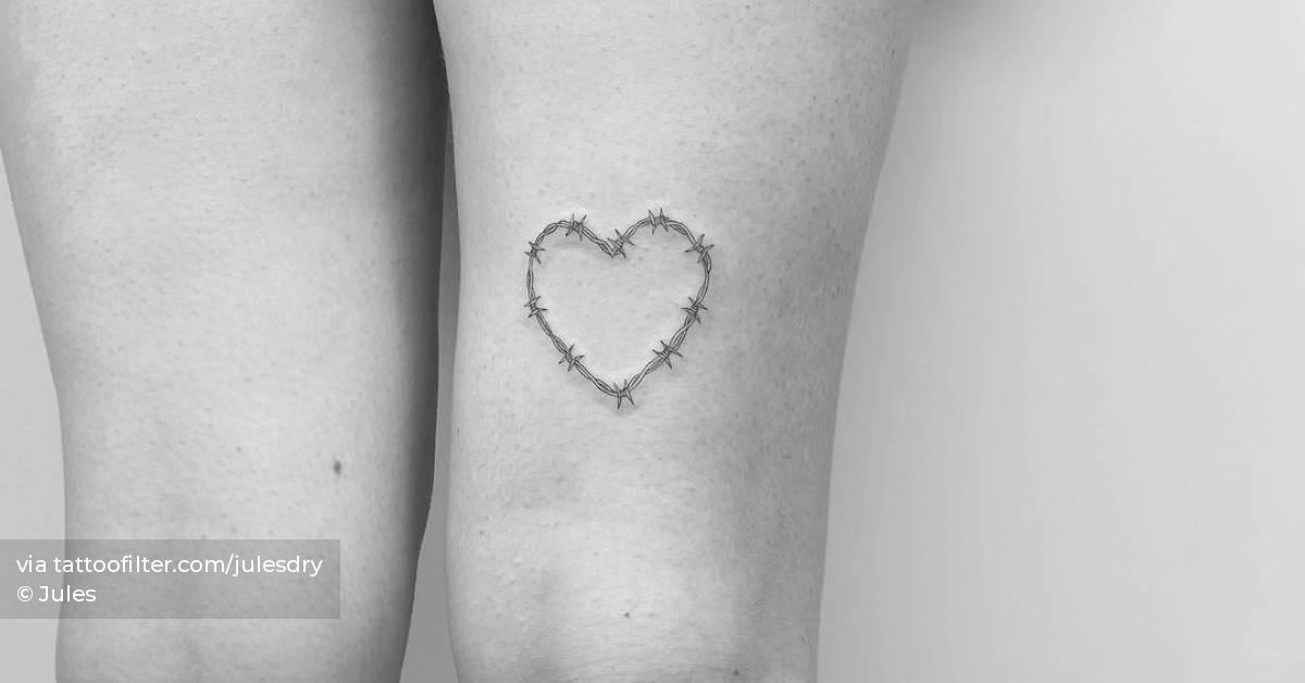 Heart shaped barbed wire tattoo on the thigh.