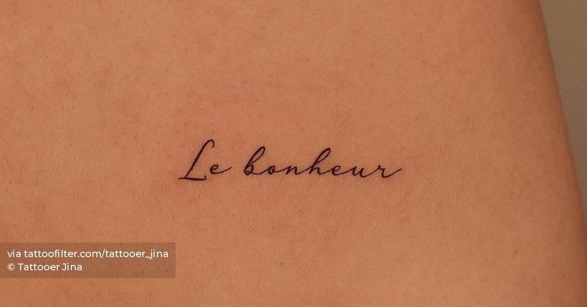 "Le bonheur" lettering tattoo on the shoulder blade.