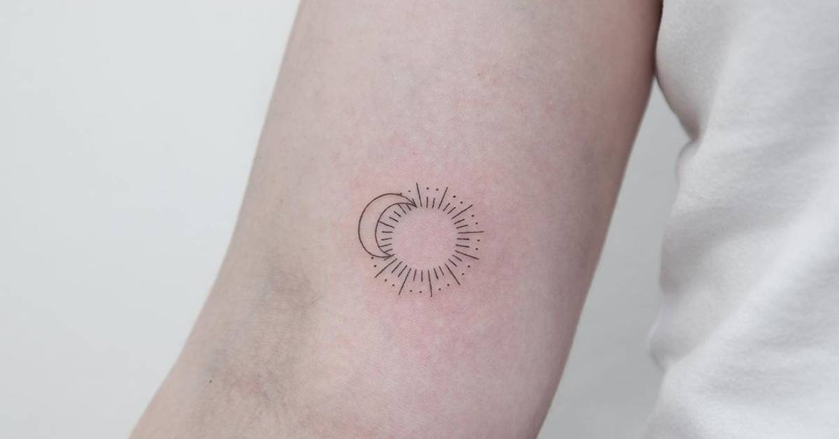 Fine line sun and moon tattoo on the inner arm.