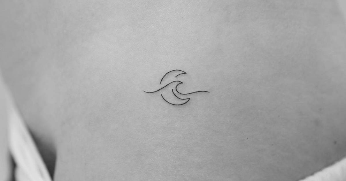 Minimalist wave and moon tattoo on the hip.
