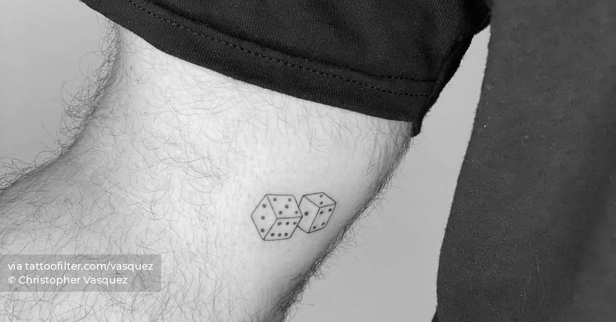 Fine line dice tattoo on the inner arm.