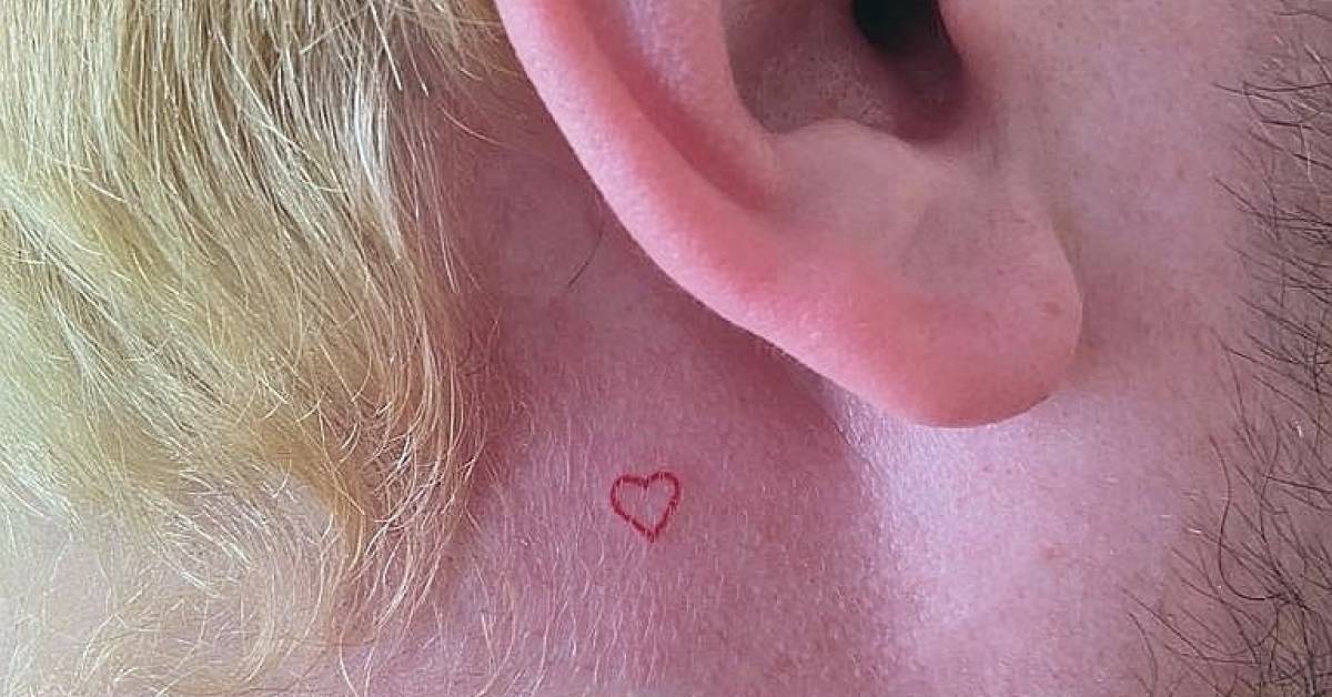 Tiny red heart tattoo on the back of the ear.