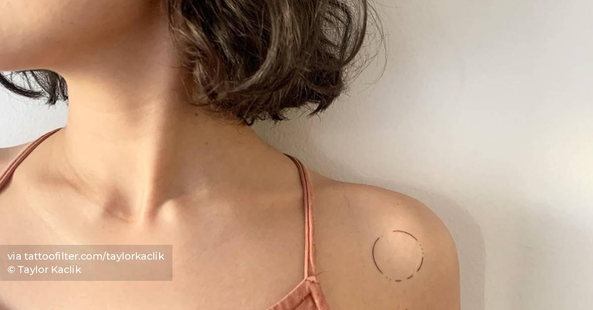Minimalist circle tattoo on the shoulder.