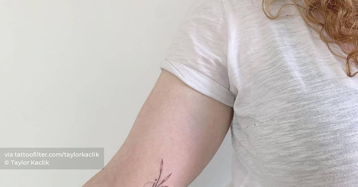 Hand poked leaves tattoo on the inner arm.