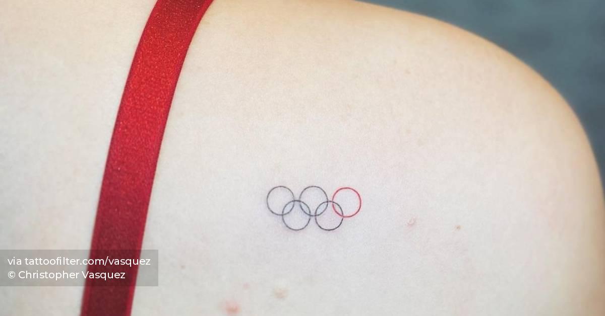 Minimalist Olympic rings tattoo on the shoulder blade.