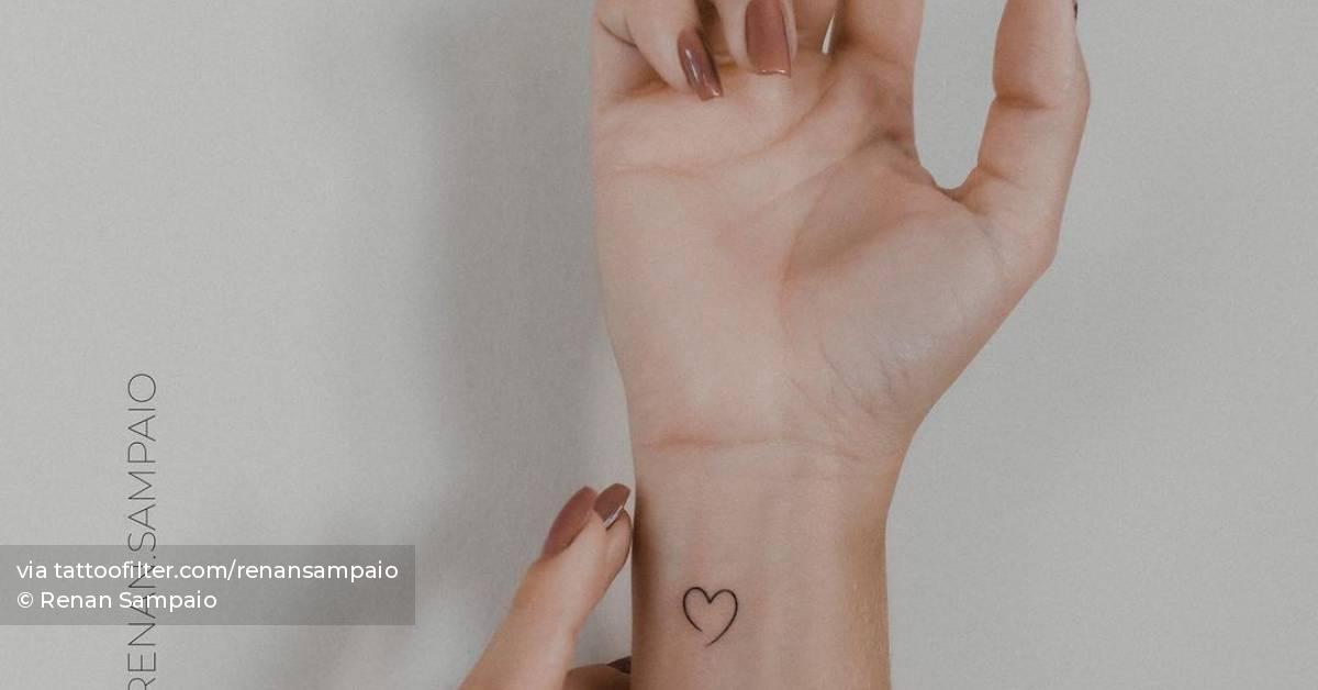 Minimalist heart tattoo on the wrist.