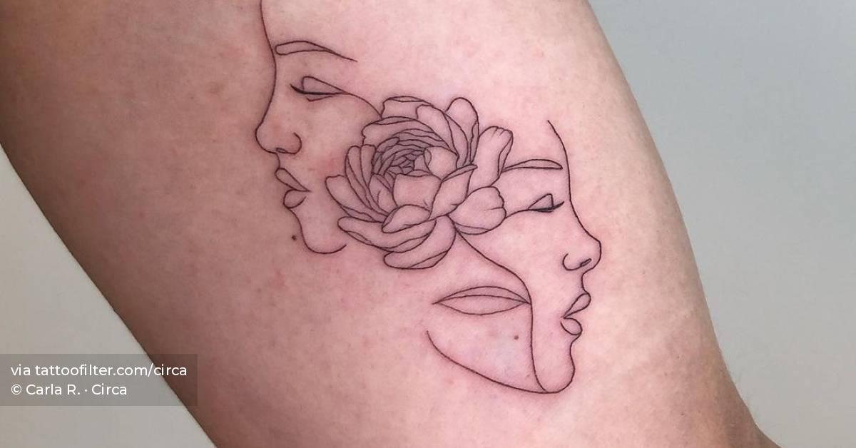 Fine line flower head woman tattoo on the inner arm.