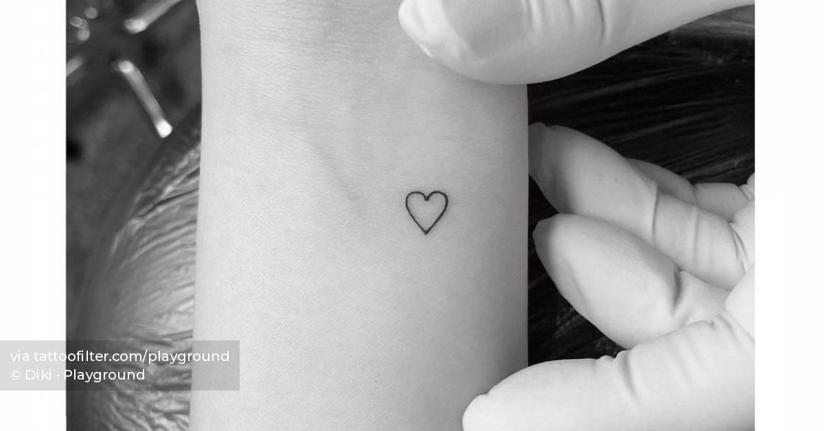 Minimalist heart tattoo on the wrist.